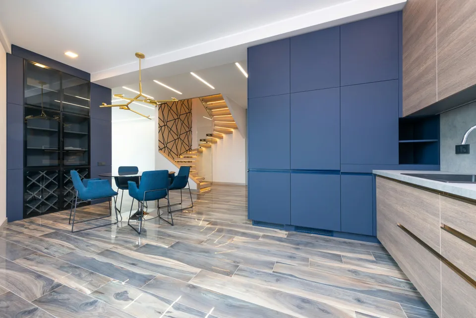 Patterned gray flooring beside blue cabinets