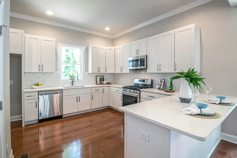 Brown wood flooring in a white cabinet kitchen