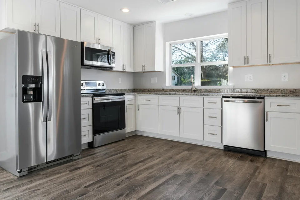 Gray plank flooring in a white cabinet kitchen